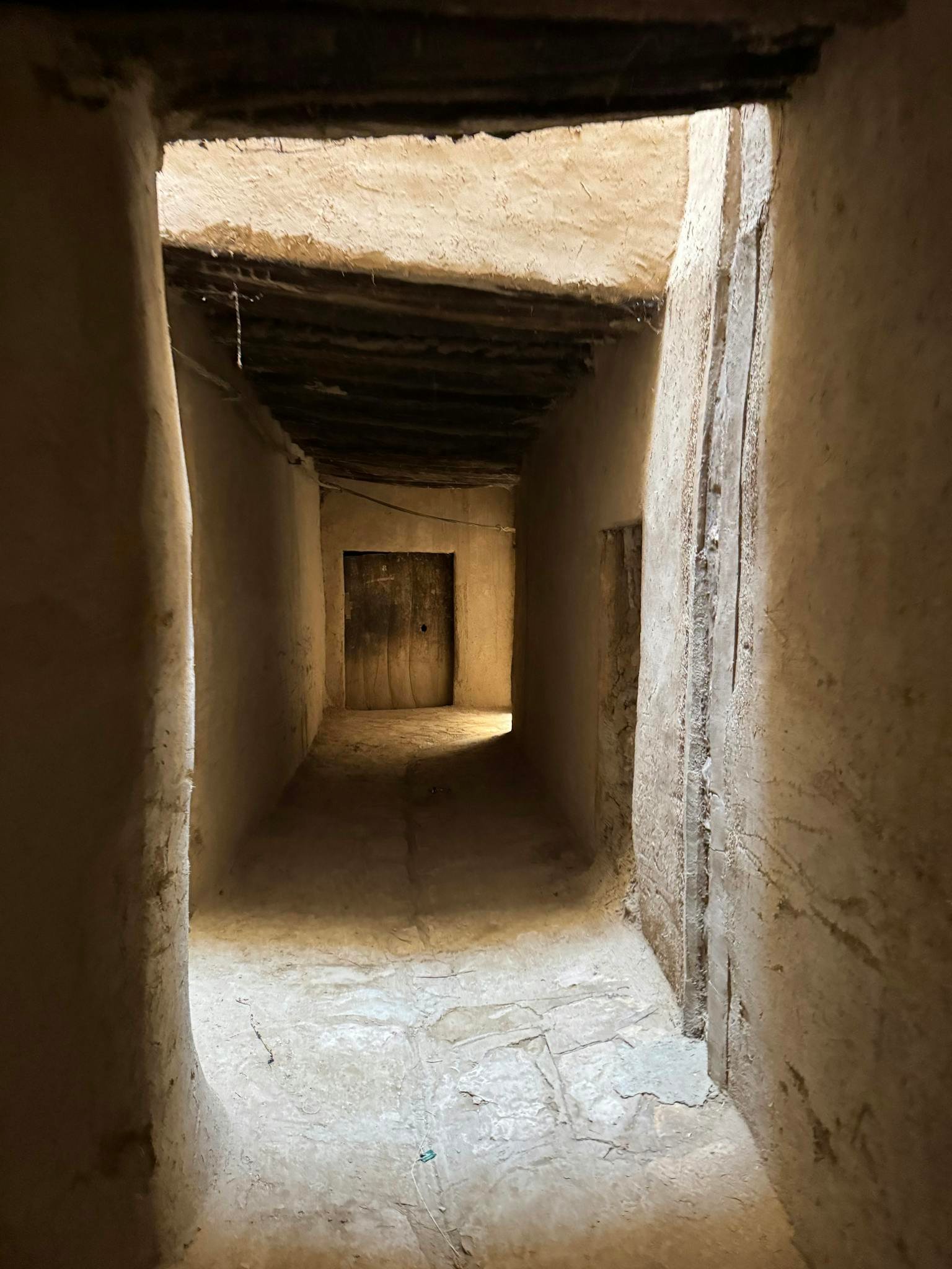 Intriguing narrow passageway with rustic wooden ceiling, capturing timeless architecture in an ancient setting.