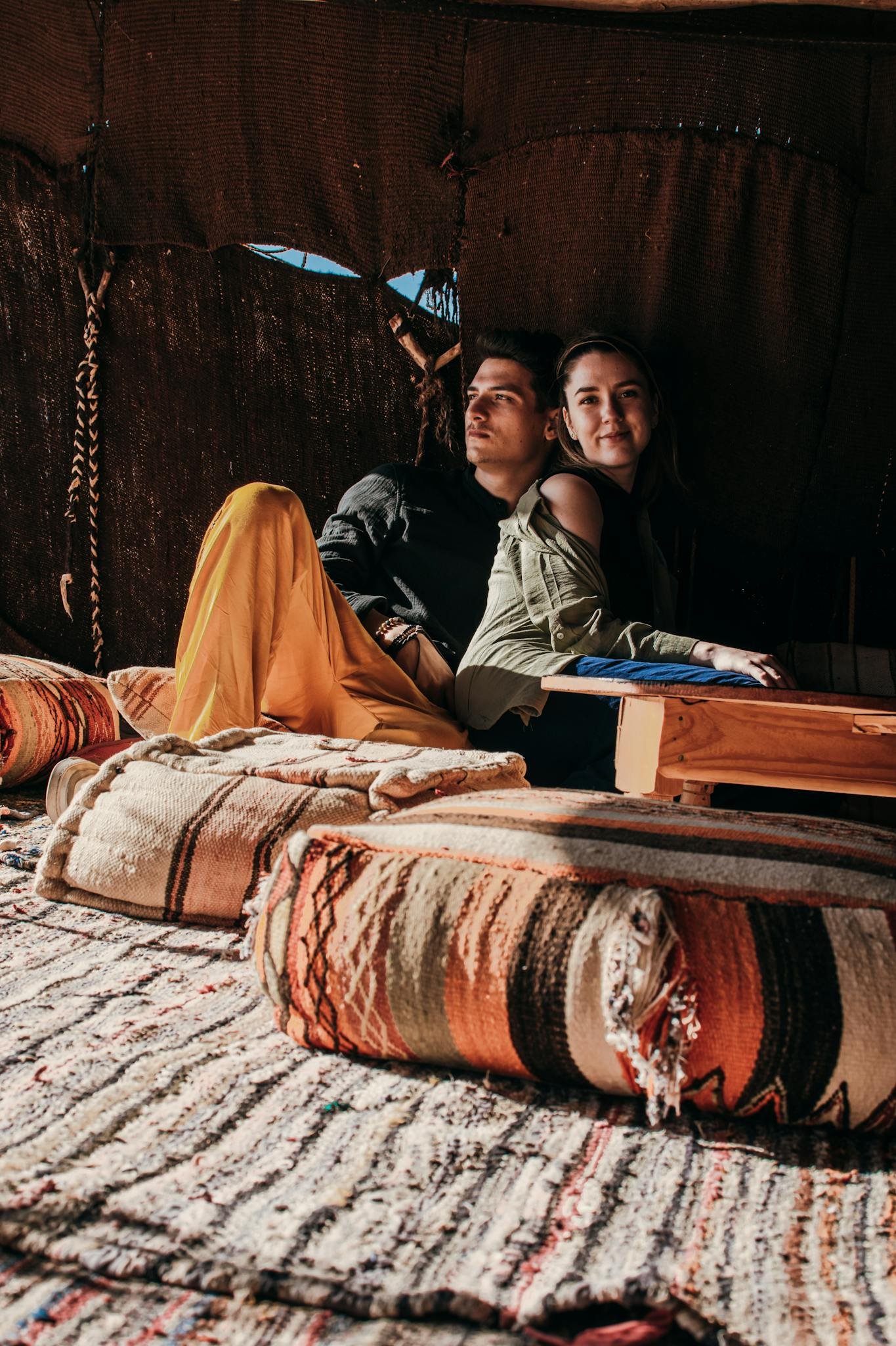 Young couple enjoying leisure time in a cozy Merzouga tent. Cultural and romantic atmosphere.